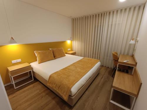 a hotel room with a large bed and a chair at Casa do Correio in Pampilhosa da Serra