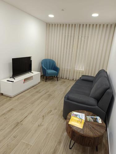 a living room with a couch and a tv at Casa do Correio in Pampilhosa da Serra