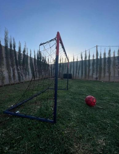 a basketball hoop with a ball in the grass at Villa Mia, Piscine chauffée, parking,Iptv in Najem