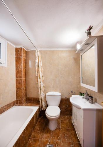 a bathroom with a toilet and a tub and a sink at Sunset Bella Vista in Athani