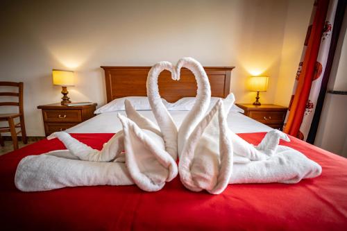 two swans made out of towels on a bed at Appartamenti Le Bistrot in Saint Nicolas