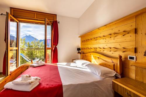 a bedroom with a large bed and a window at Appartamenti Le Bistrot in Saint Nicolas