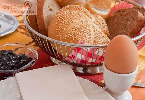 a table topped with a basket of bread and eggs at Sporthotel Bergheim in Sölden