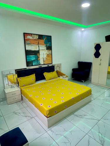 a bedroom with a large yellow bed and a chair at Résidence Turpin in Toubab Dialaw