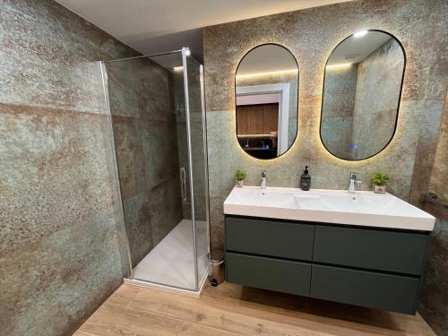 a bathroom with a sink and two mirrors at LOFT Accommodative A in Valencia
