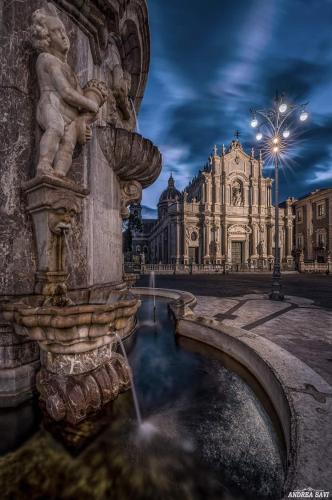 a statue of a fountain in front of a building at B&B Domus Pina in Catania