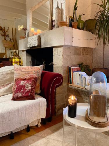 - un salon avec un canapé et une cheminée avec une bougie dans l'établissement Casa Bohême, à Caunes-Minervois