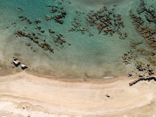 an overhead view of a beach with a group of rocks in the water at Apartment Cinema in Savudrija