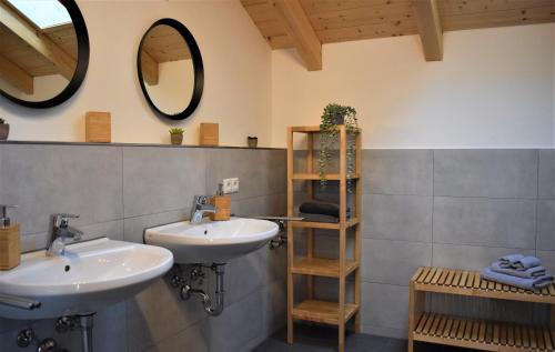 a bathroom with two sinks and a mirror at Ferienwohnungen Rosenheim - Pang in Rosenheim
