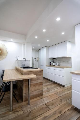 une cuisine avec des armoires blanches et une table en bois dans l'établissement Bel appartement - Nice centre, à Nice