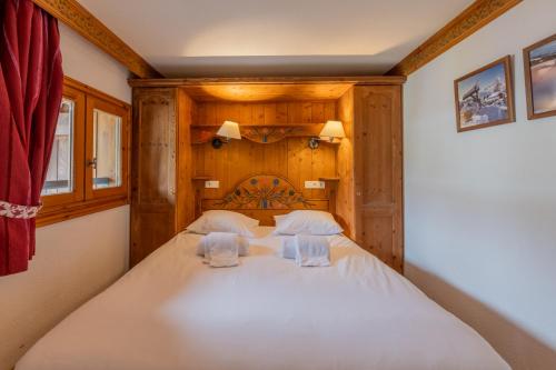 une chambre avec un grand lit blanc avec deux oreillers dans l'établissement Residence Le Cristal - Grands Montets 20 - Happy Rentals, à Chamonix-Mont-Blanc