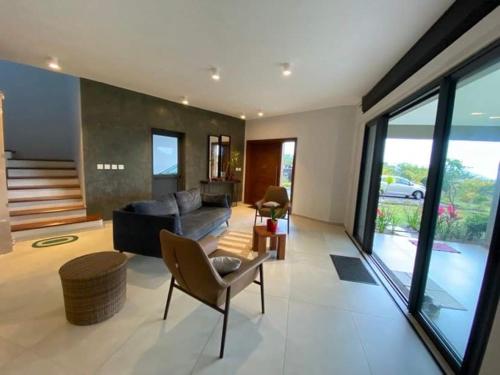 a living room with a couch and a chair at Magnifique maison moderne avec vue in Floréal