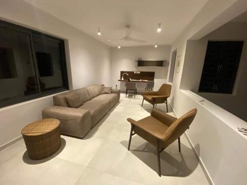 a living room with a couch and chairs and a piano at Magnifique maison moderne avec vue in Floréal