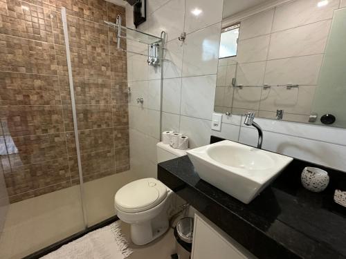 a bathroom with a sink and a toilet and a shower at Flor de Limão Hotel Boutique in Coroa Vermelha