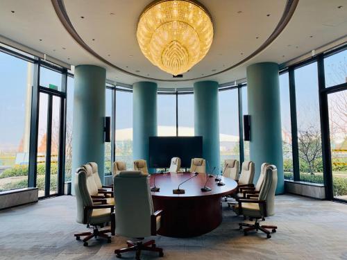a conference room with a table and chairs and a large chandelier at EVEN Hotel Nanjing Yangtze River by IHG in Nanjing