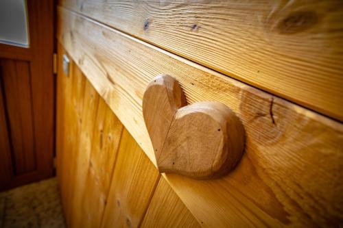 a wooden heart on the side of a wooden wall at Appartamenti Le Bistrot in Saint Nicolas