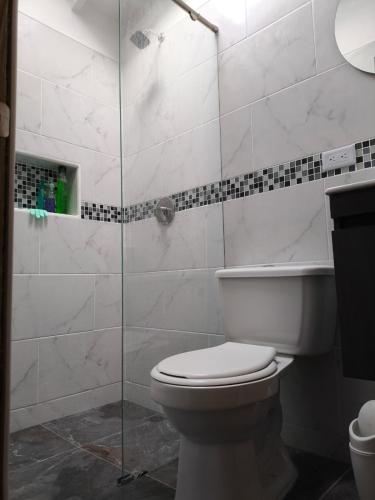 a bathroom with a toilet and a glass shower at Casa Pino Campestre Panorámica in Jericó