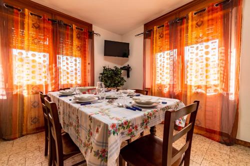 a dining room with a table and chairs and curtains at Appartamenti Le Bistrot in Saint Nicolas
