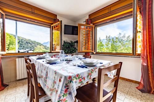 a dining room with a table and some windows at Appartamenti Le Bistrot in Saint Nicolas