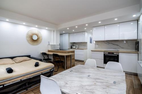 une chambre avec un lit, une table et des chaises dans l'établissement Bel appartement - Nice centre, à Nice