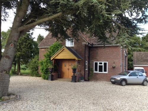 a brick house with a car parked in front of it at B&B Dorwyn Manor in Avebury