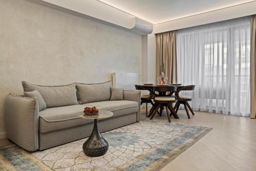 ein Wohnzimmer mit Sofa und Tisch in der Unterkunft Apartament Luxury Cortina North Residence Pipera in Voluntari