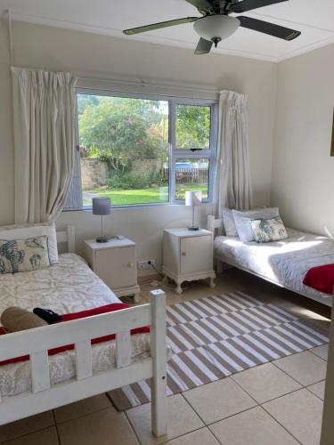 una camera da letto con due letti e una finestra di Sandpiper Cottage a Kleinemonde
