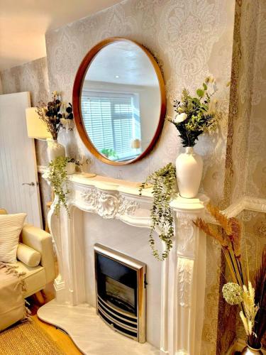 a mirror over a fireplace in a living room at The Secret Garden Retreat With Hot Tub in Manchester