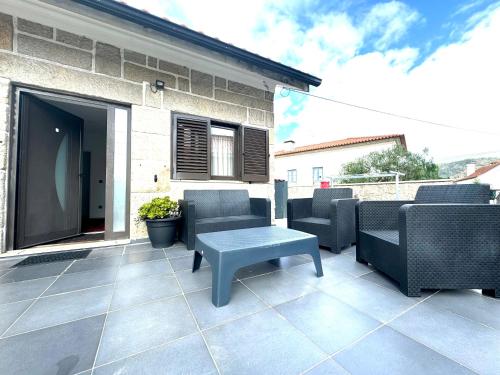 a patio with chairs and a bench and a table at Casa Avô Cantoneiro - Cepães Marinhas in Cepães