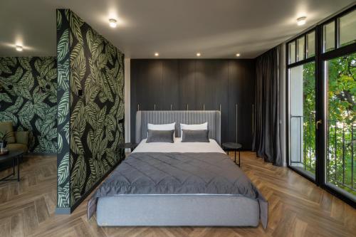 a bedroom with a large bed and a large window at Ridge Apartments in Chernivtsi