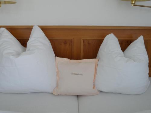 a group of pillows sitting on top of a bed at Pension Lichterturm in Beuren