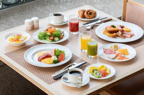 a table with plates of food and cups of coffee at ANA Crowne Plaza Toyama by IHG in Toyama