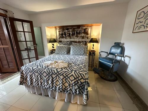 a bedroom with a bed and a blue chair at Flor de Limão Hotel Boutique in Coroa Vermelha