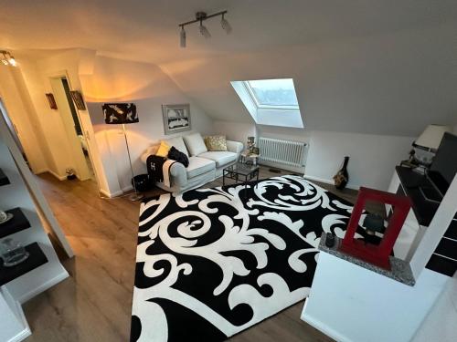 a living room with a white couch and a black and white rug at Ferienwohnung Gütersloh in Gütersloh