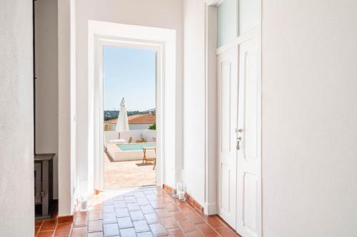 an open door into a room with a view of a pool at Guesthouse Casa Felicia in Montes de Alvor