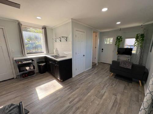 a kitchen and living room with a couch and a table at Bright & Comfortable Bungalow! in East Tulsa