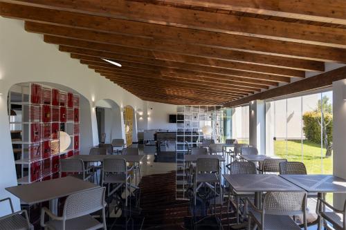 a dining room with tables and chairs and windows at Hotel San Teodoro in San Teodoro