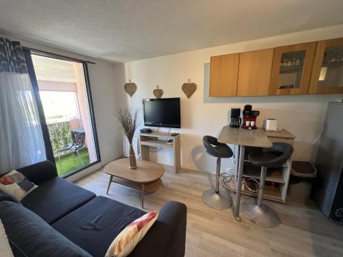 un salon avec un canapé et une table dans l'établissement T2 cap d'agde, au Cap d'Agde