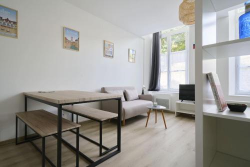 un salon avec une table et un canapé dans l'établissement Au Cœur des Remparts - Studio 2p, vieille ville BSM, à Boulogne-sur-Mer