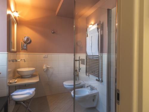a bathroom with two toilets and a glass shower at Hotel San Pietro Palace in Finale Ligure