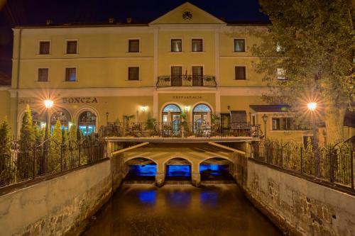 un pont sur une rivière devant un bâtiment dans l'établissement Hotel Bończa, à Szczecin