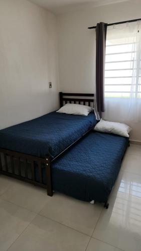 a bedroom with two beds and a window at Bonito departamento en planta baja en Manzanillo con Alberca in Manzanillo