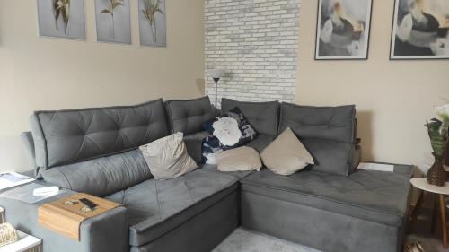 a gray couch with pillows in a living room at Apartamento Central in Ponta Grossa