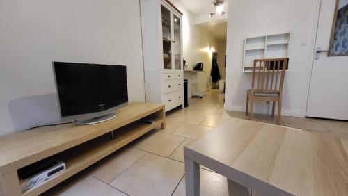 un salon avec une télévision à écran plat sur une table dans l'établissement Studio rénové proche cathédrale, à Chartres
