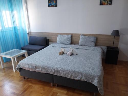 a bedroom with a bed with two stuffed animals on it at Petrograd Apart. in Bitola