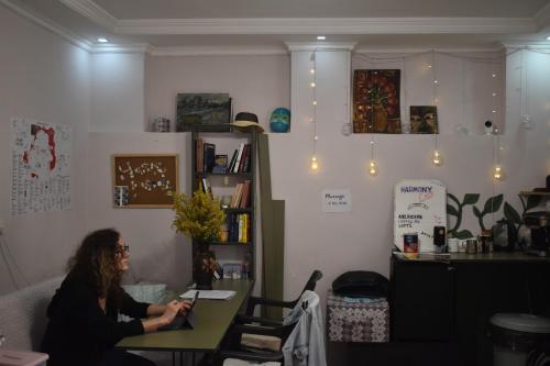 バトゥミにあるHarmony Backpackers Hostelの部屋のテーブルに座る女性