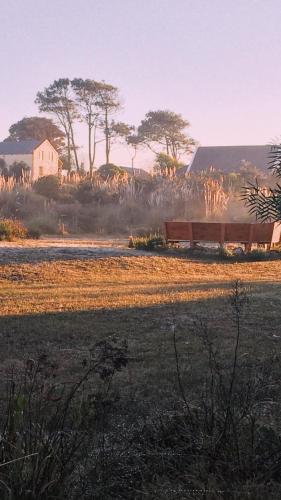 a train traveling through a field with a house in the background at Angelo in Punta Del Diablo