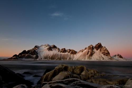 a mountain range with snow on it at sunset at Guesthouse Birkifell in Nesjum