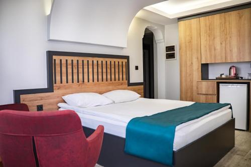 una camera da letto con un letto e una sedia rossa di Ladik Hotel a Karahayit