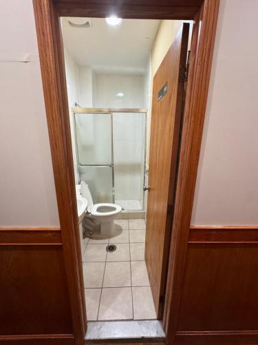 a bathroom with a toilet and a glass shower at U.S. Pacific Hotel in New York